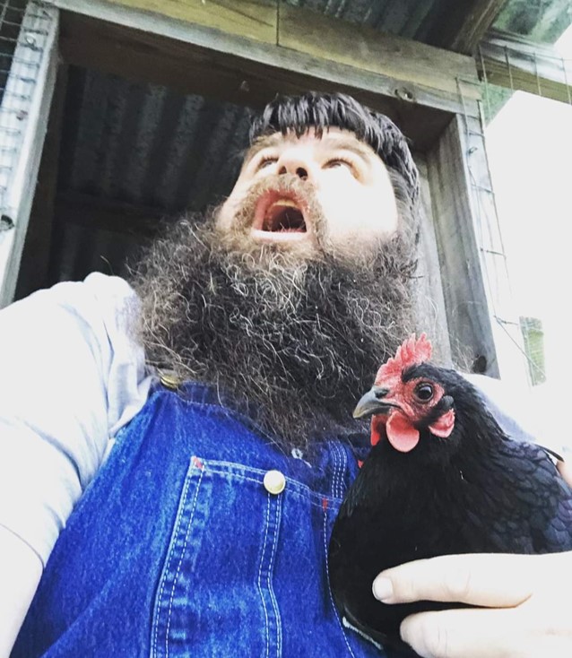 Dad holding a chicken in overalls